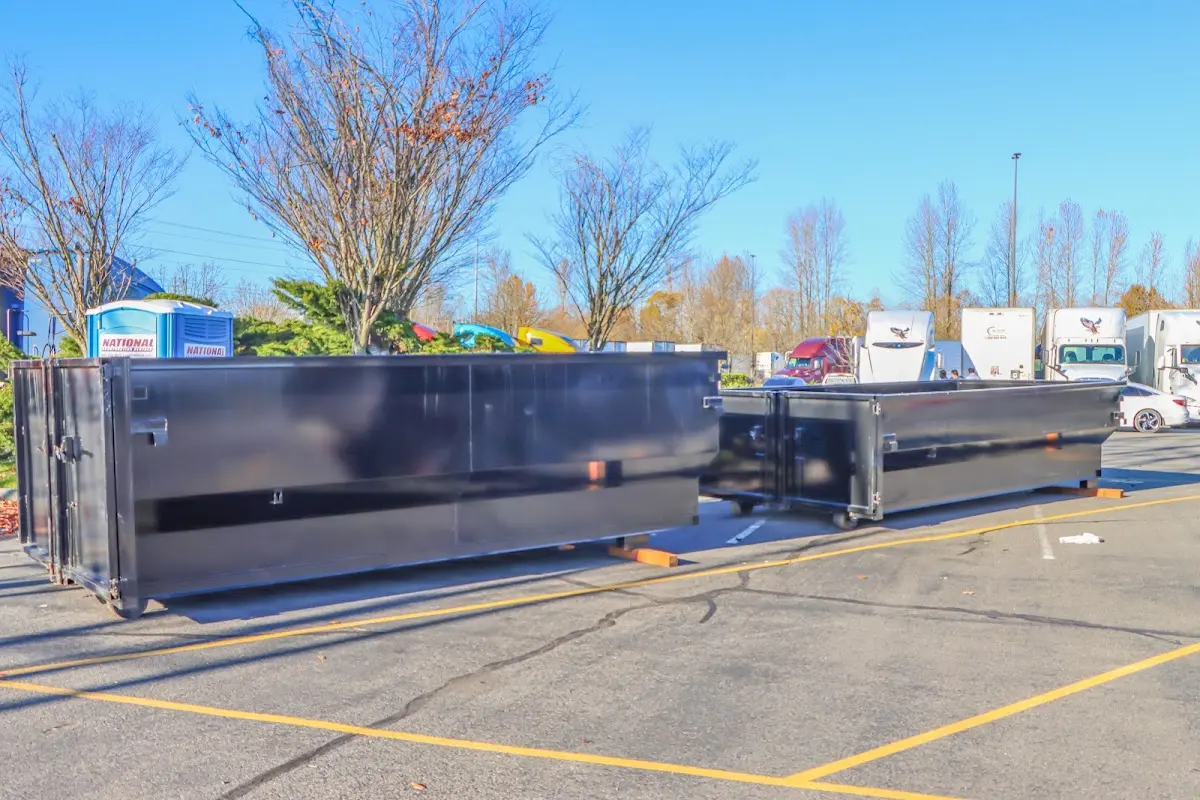 Professional dumpster rental service with roll-off container on residential driveway in Watauga